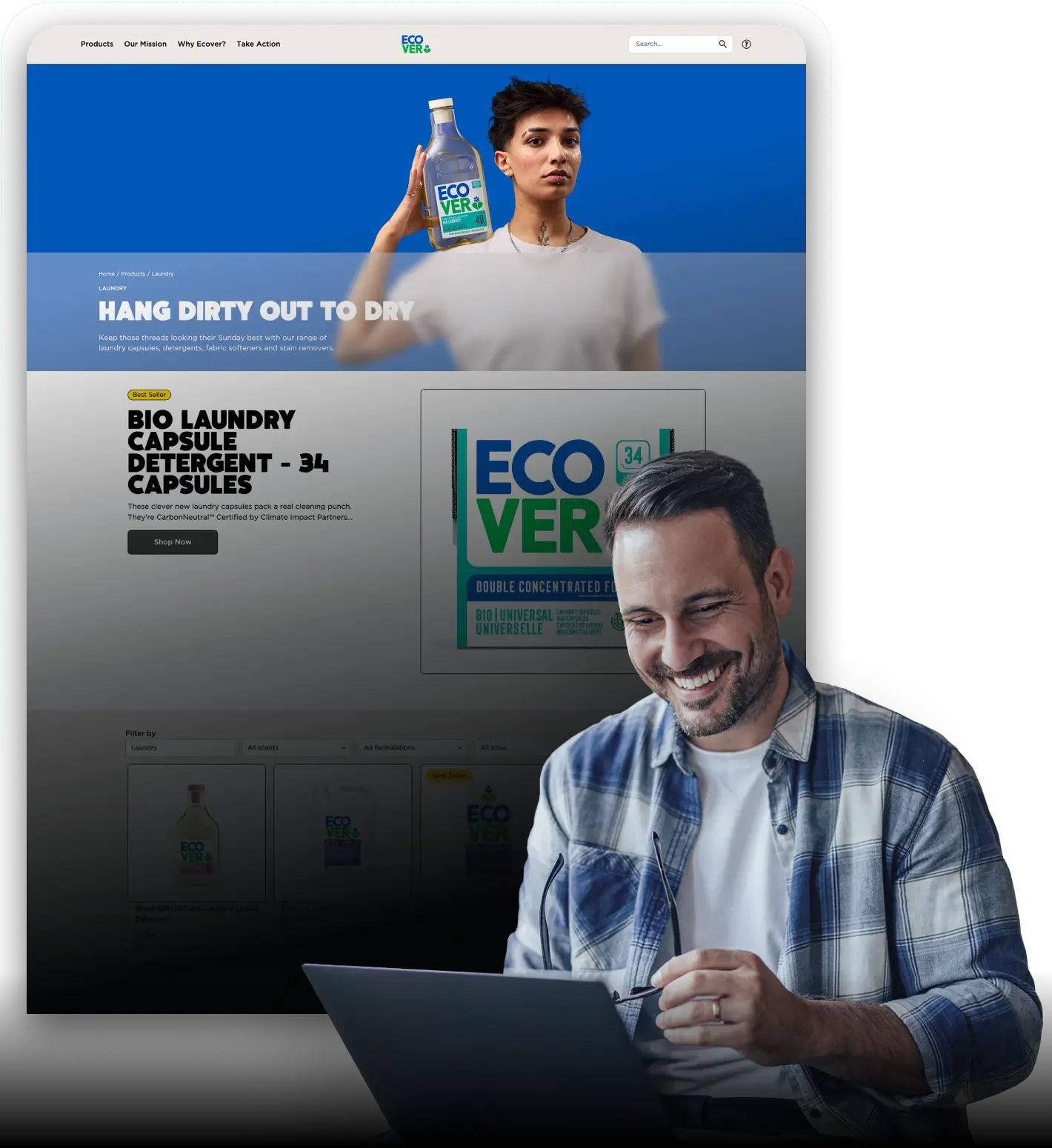 A man smiling while working on a laptop in the foreground, with a large digital display behind him showing a product website for “Ecover” laundry detergent, featuring a person holding a bottle and product details on screen.