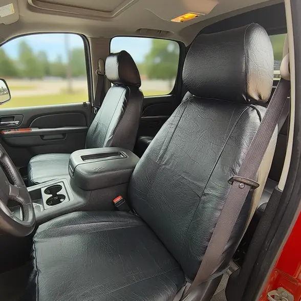Durafit seat cover used on a truck seat. Close-up of a vehicle’s front interior featuring black Durafit seat covers installed on the driver and passenger seats, highlighting a snug fit, durable material, and clean, factory-style appearance.
