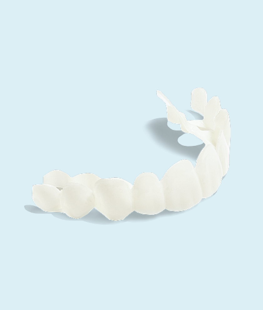 A close-up image of a single upper dental veneer or removable clip-on smile (possibly a cosmetic dental appliance) displayed against a pale blue background. The curved row of white, glossy teeth is designed to fit over the upper set of natural teeth, suggesting a product used for aesthetic dental enhancement.