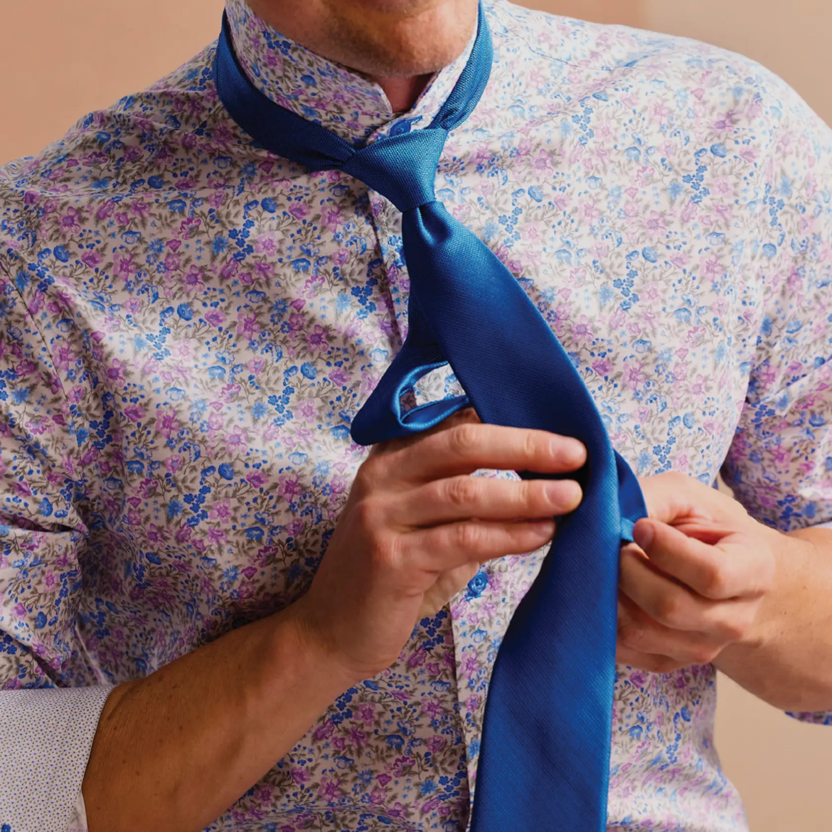 man in shirt tying a tie